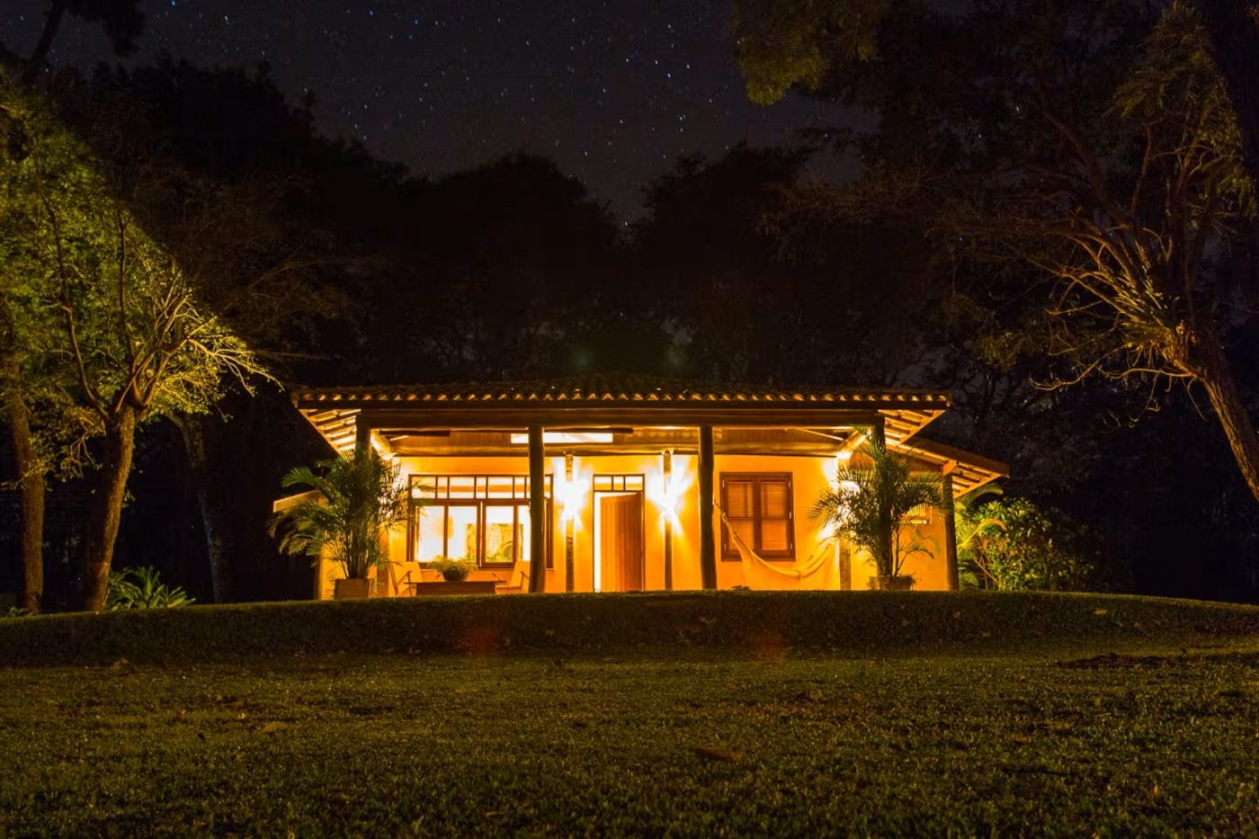 Casa de hóspedes iluminada à noite sob as estrelas